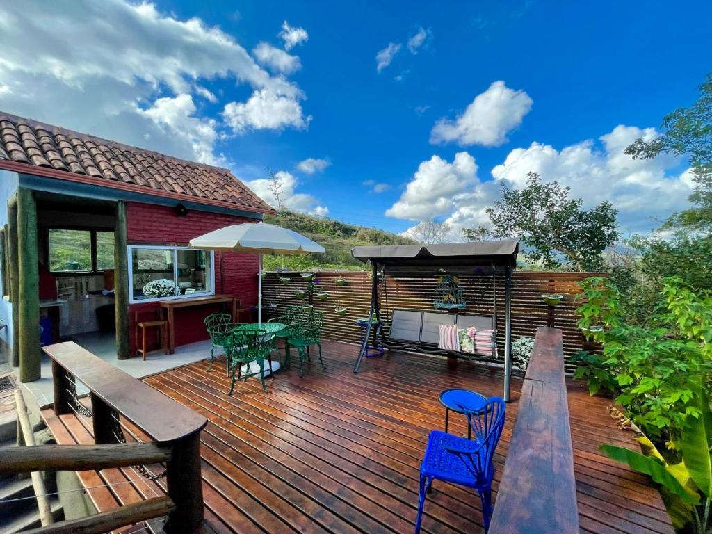 Deck gourmet de madeira com churrasqueira, balanço e vista para as montanhas
