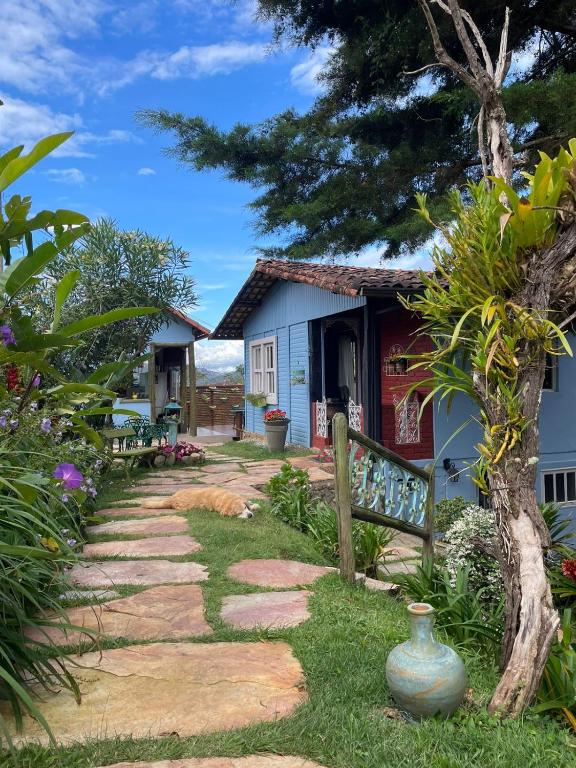 Casas de madeira coloridas com jardim florido e caminho de pedra
